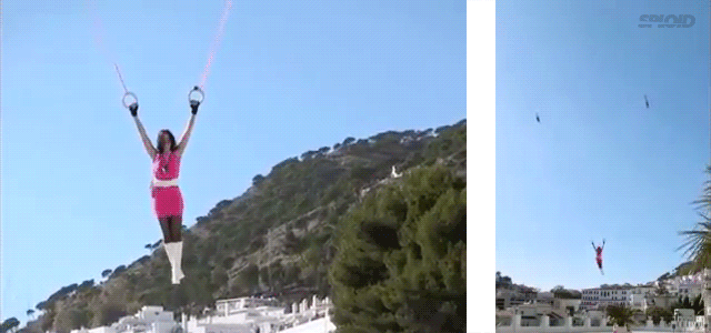 Holy Crap, This Woman Is Flying Hanging From Two Toy Helicopters!