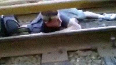 Crazy Kid Crawls Across The Railway Tracks Under A Running Train