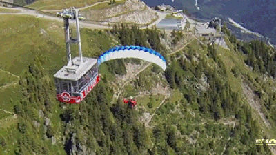 Paraglider Flies So Close To Cable Car That He Can High-Five Passengers
