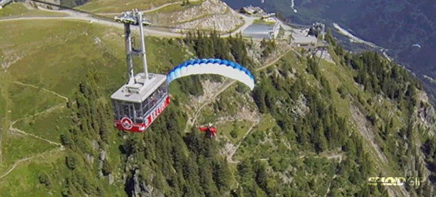Paraglider Flies So Close To Cable Car That He Can High-Five Passengers
