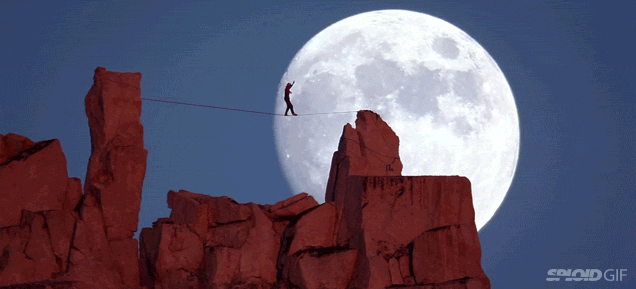 Guy Walking On A Tight Rope Against A Beautiful Giant Moon