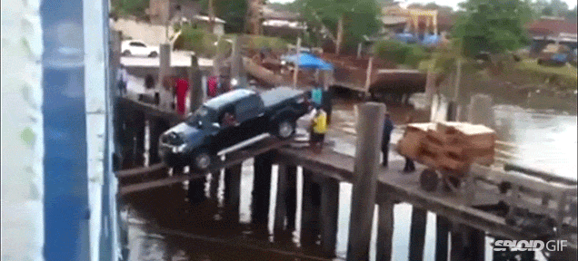 Truck Boards A Ship By Wildly Driving Down Two Thin Wooden Planks