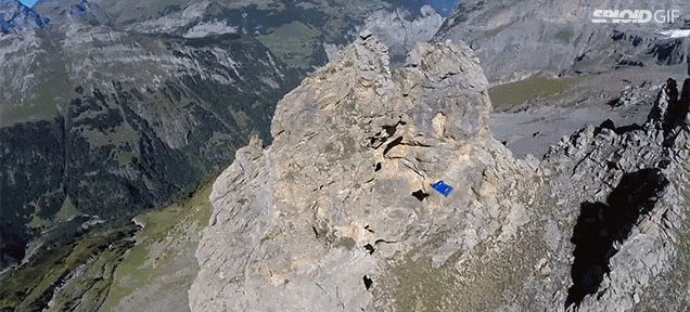 Flying Man In Wing Suit Slices Right Through A Hole In A Mountain