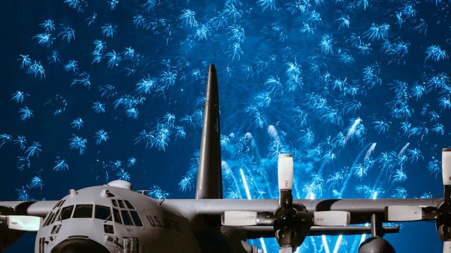Electric Blue Fireworks Light Up The Sky Behind A C-130 Hercules Plane