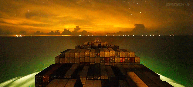A Container Ship Travelling Around The Ocean At Night Is One Of The Most Beautiful Things