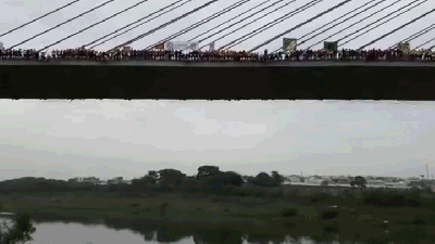 Watch 245 People Jump And Swing Off A Bridge Like A Giant Dangling Snake