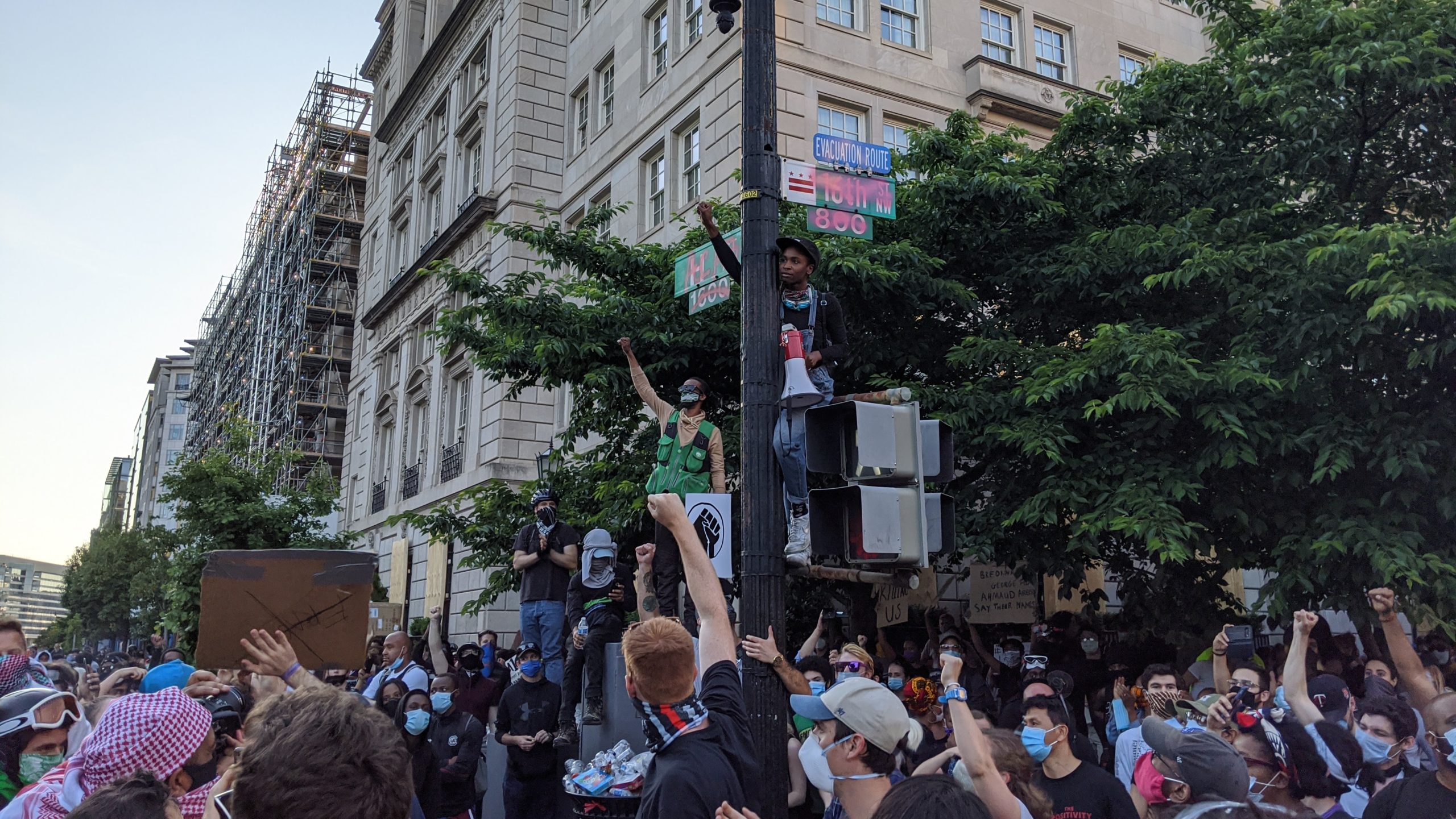 Protest organisers scale a stoplight outside LaFayette Square in DC on June 2. (Photo: Tom McKay, Gizmodo)