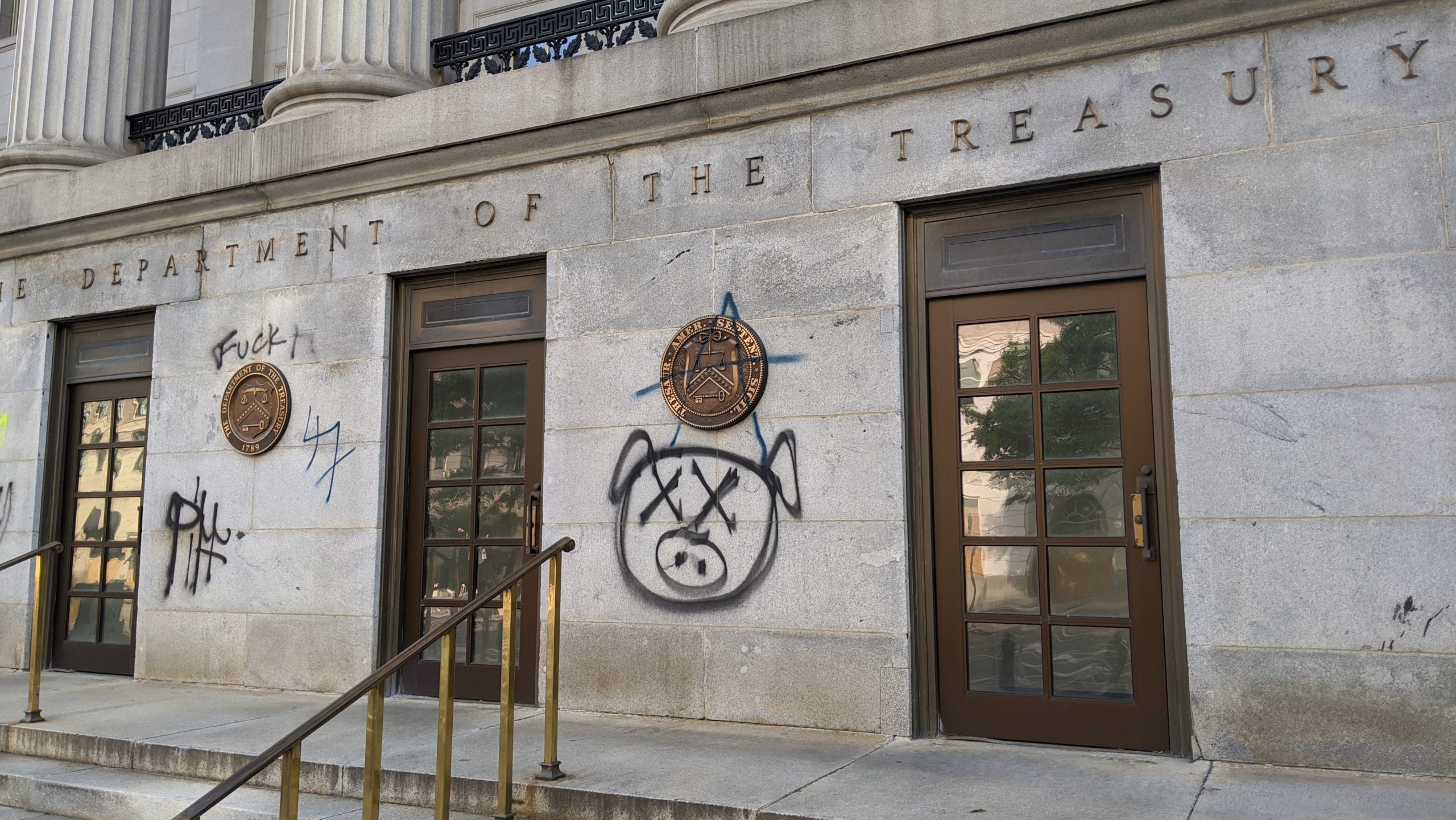 Pig graffiti on the entrance of the U.S. Treasury Department, June 2. (Photo: Tom McKay, Gizmodo)