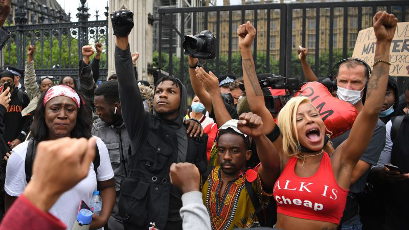 John Boyega raises a fist of solidarity alongside protesters outside Parliament Square in London, England. (Image: Daniel Leal-Olivas/AFP, Getty Images)