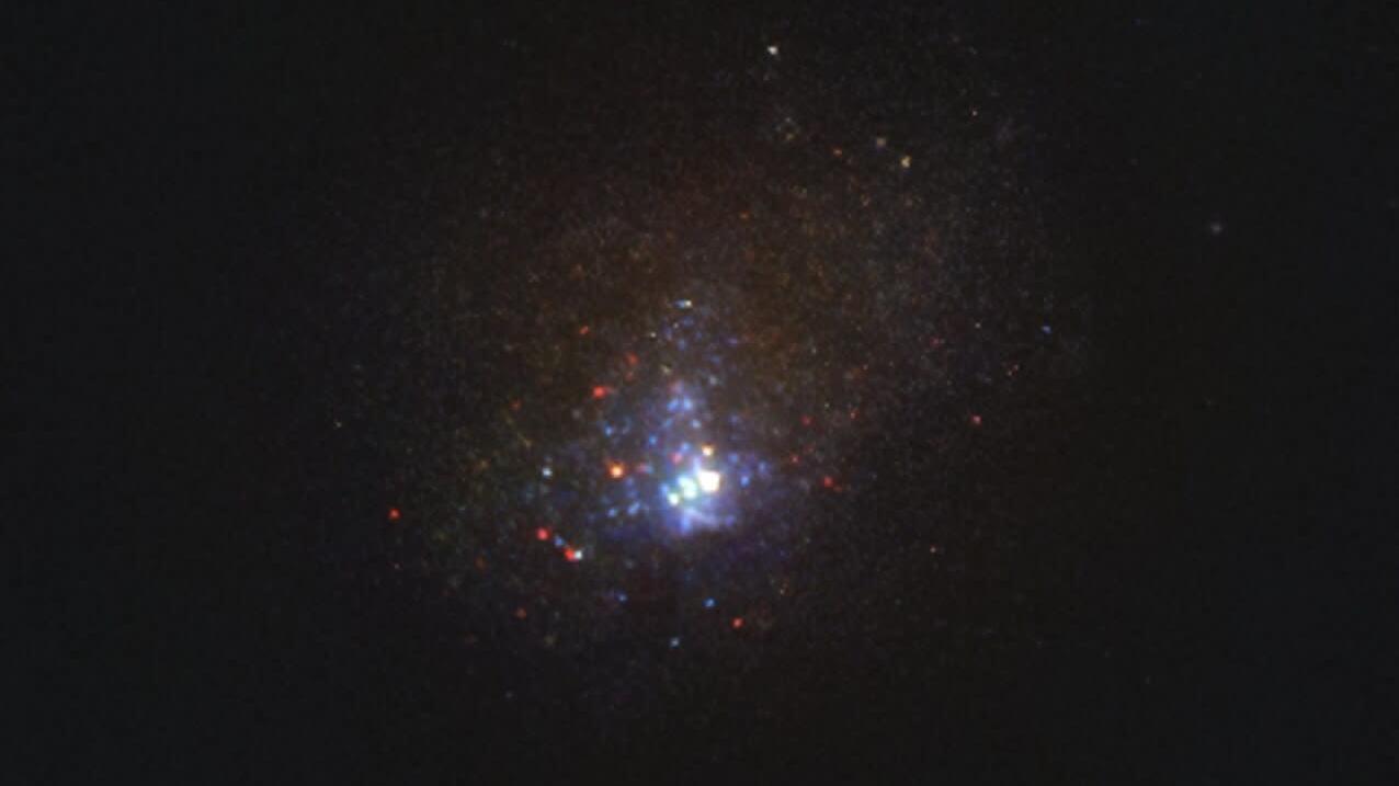 Image of the Kinman Dwarf galaxy, also known as PHL 293B. This tiny galaxy is too far for scientists to pick out individual stars, so what look like stars in this Hubble image are either stars in foreground or gigantic star clusters within the galaxy itself.  (Image: NASA, ESA/Hubble, J. Andrews)