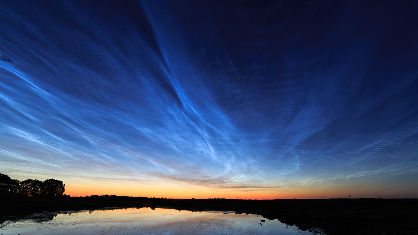Noctilucent clouds hang over a lake at sunset. (Photo: Wikimedia)