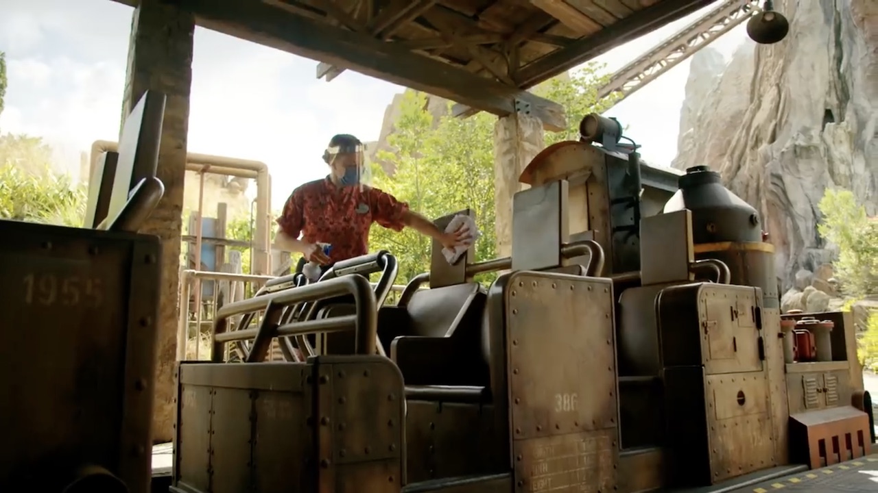 A Disney cast members wipes down a ride vehicle in a new video released by Disney Parks on YouTube. (Screenshot: Disney Parks/YouTube)