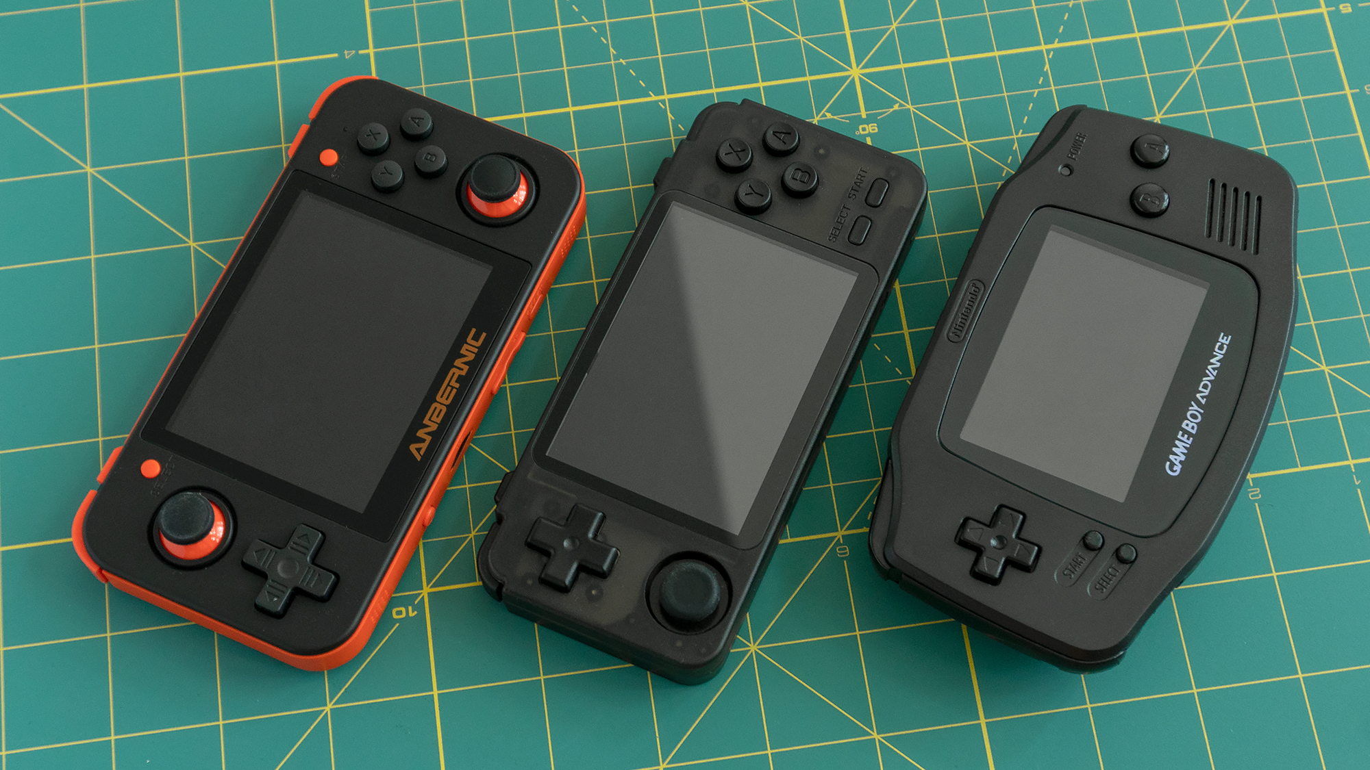 The RK2020 (middle) hits a sweet spot in terms of size between the RG350 (left) and the original Nintendo Game Boy Advance (right). (Photo: Andrew Liszewski - Gizmodo)