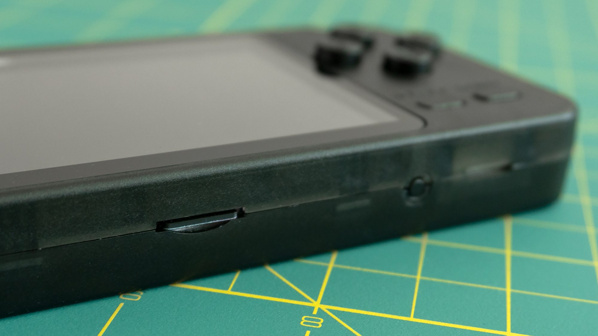 On the bottom you'll find a reset button, a slot for the speaker, and a single microSD card slot, which is one of the handheld's biggest challenges. (Photo: Andrew Liszewski - Gizmodo)