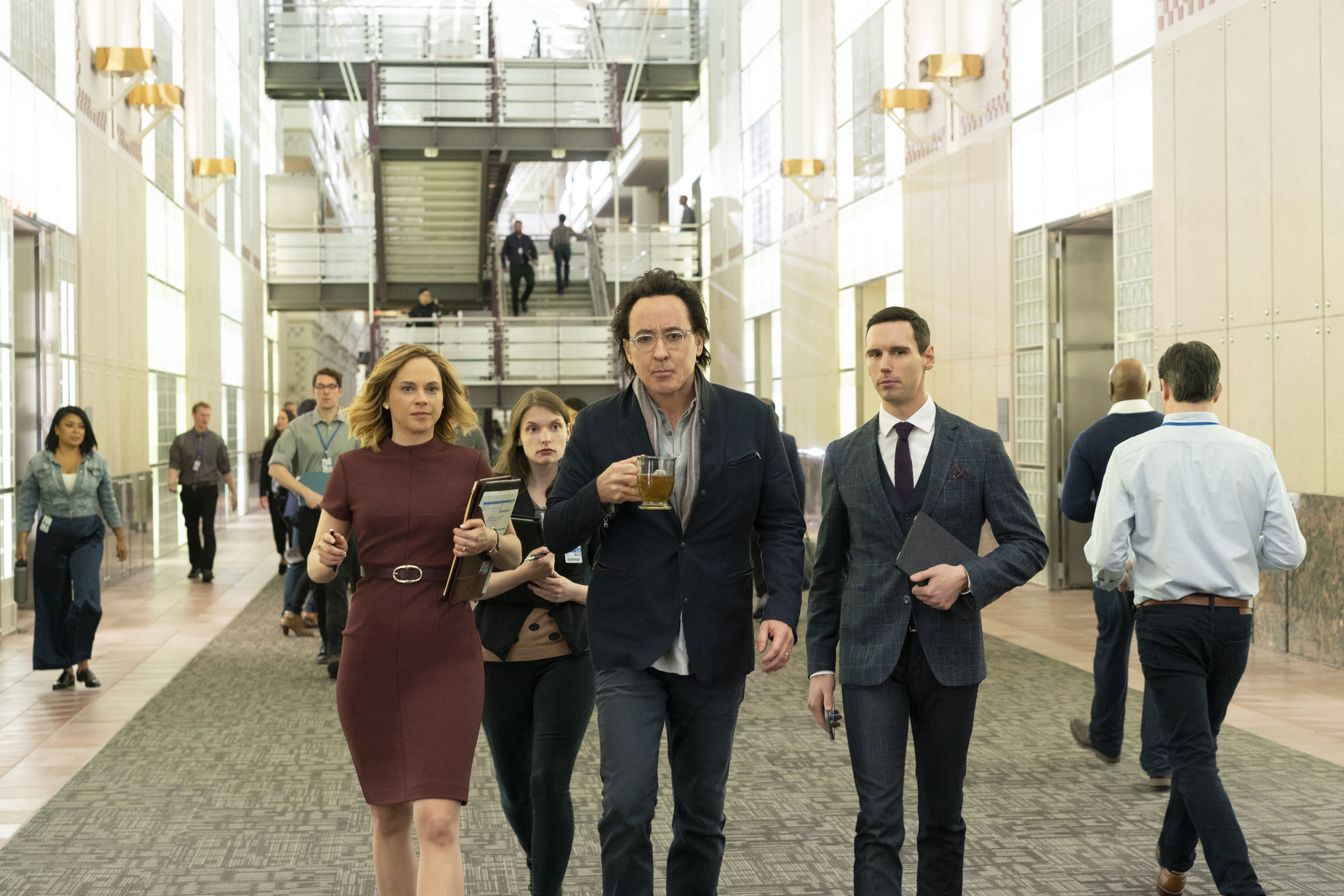 John Cusack (centre holding glass) and Cory Michael Smith (right wearing tie) on Utopia. (Photo: Elizabeth Morris/Amazon Prime Video)