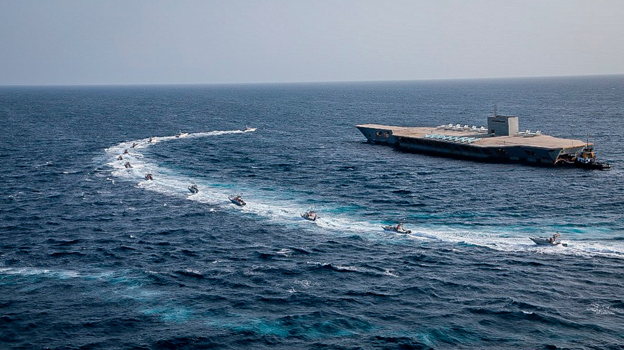 IRGC speedboats circling a mock aircraft carrier during exercises in a photo released on July 28, 2020. This photo was released by the IRGC and cannot be independently verified. (Photo: Sepahnews, AP)