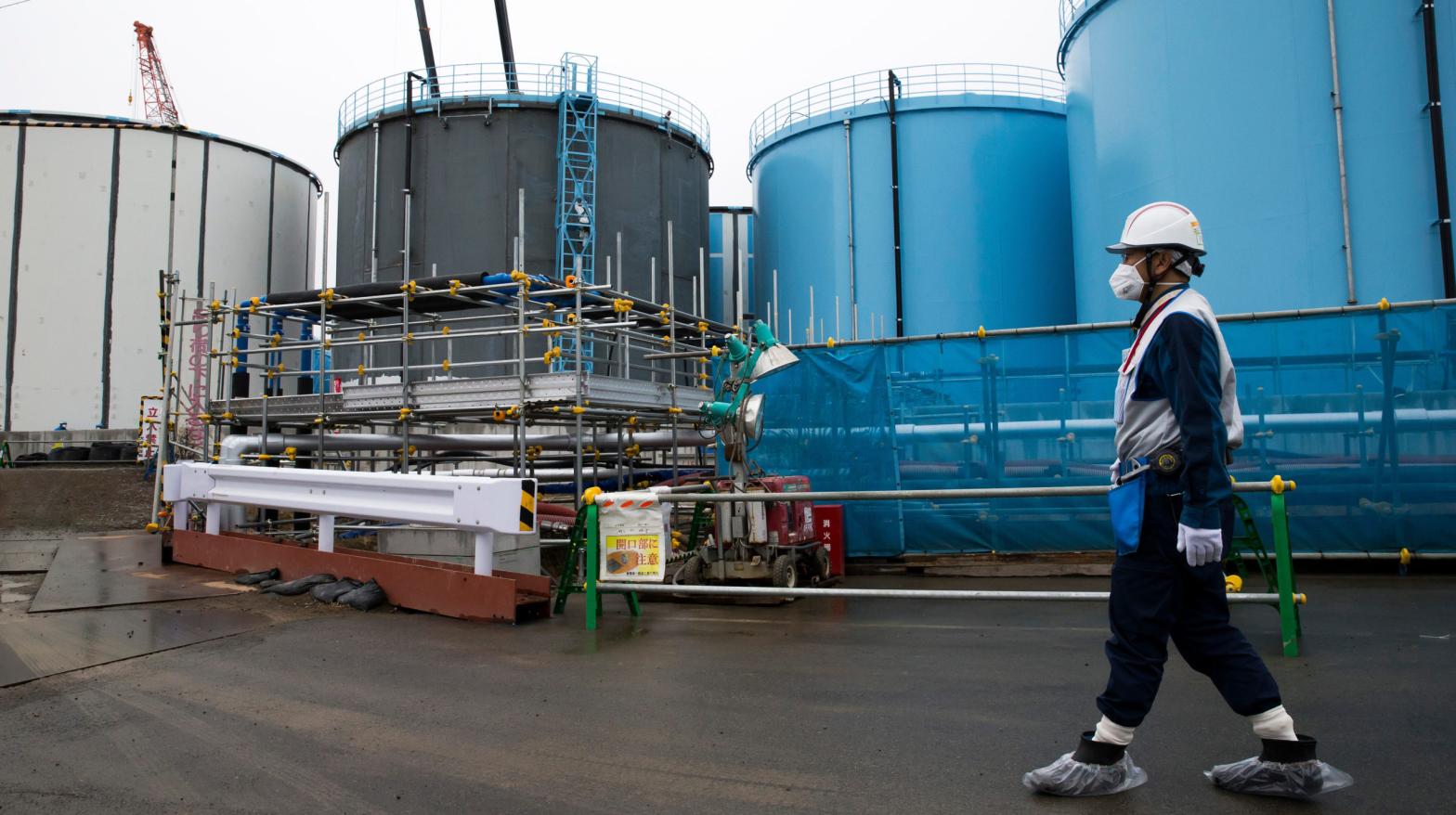A person walks past storage tanks for contaminated water at the company's Fukushima Daiichi Nuclear Power Plant (Photo: Tomohiro Ohsumi/AFP, Getty Images)