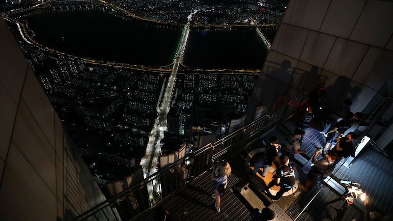 People take pictures and videos as they stay overnight on the rooftop of the Lotte World Tower as a way to safely social distance while camping in an urban setting on August 07, 2020 in Seoul, South Korea. (Photo: Chung Sung-Jun, Getty Images)