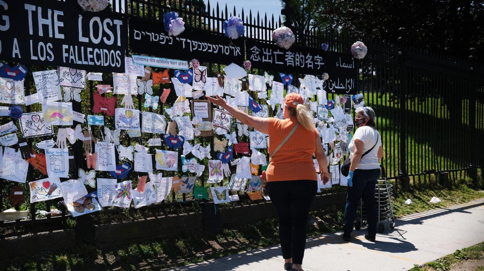 People walk by a memorial for those who have died from the coronavirus outside Green-Wood Cemetery on May 27, 2020. (Photo: Spencer Platt, Getty Images)