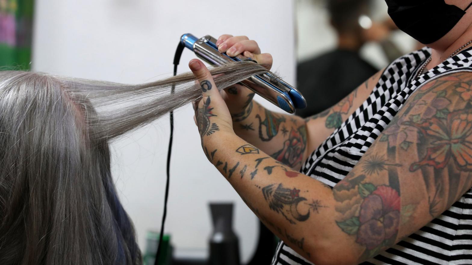 A salon worker using a curling iron. (Photo: Justin Sullivan, Getty Images)