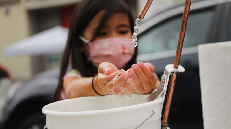 A student washes her hands at the outdoor learning demonstration at Public School 15. (Photo: Spencer Platt, Getty Images)