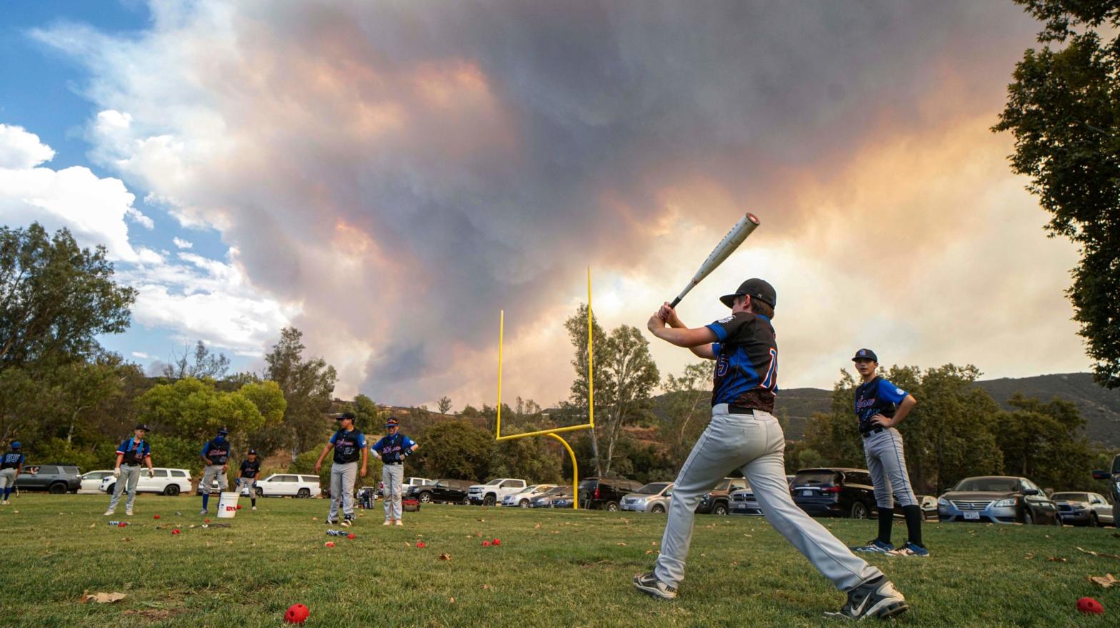 Little League players warm up before a game as the Valley Fire burns in the background near San Diego. (Photo: Sandy Huffaker/AFP, Getty Images)