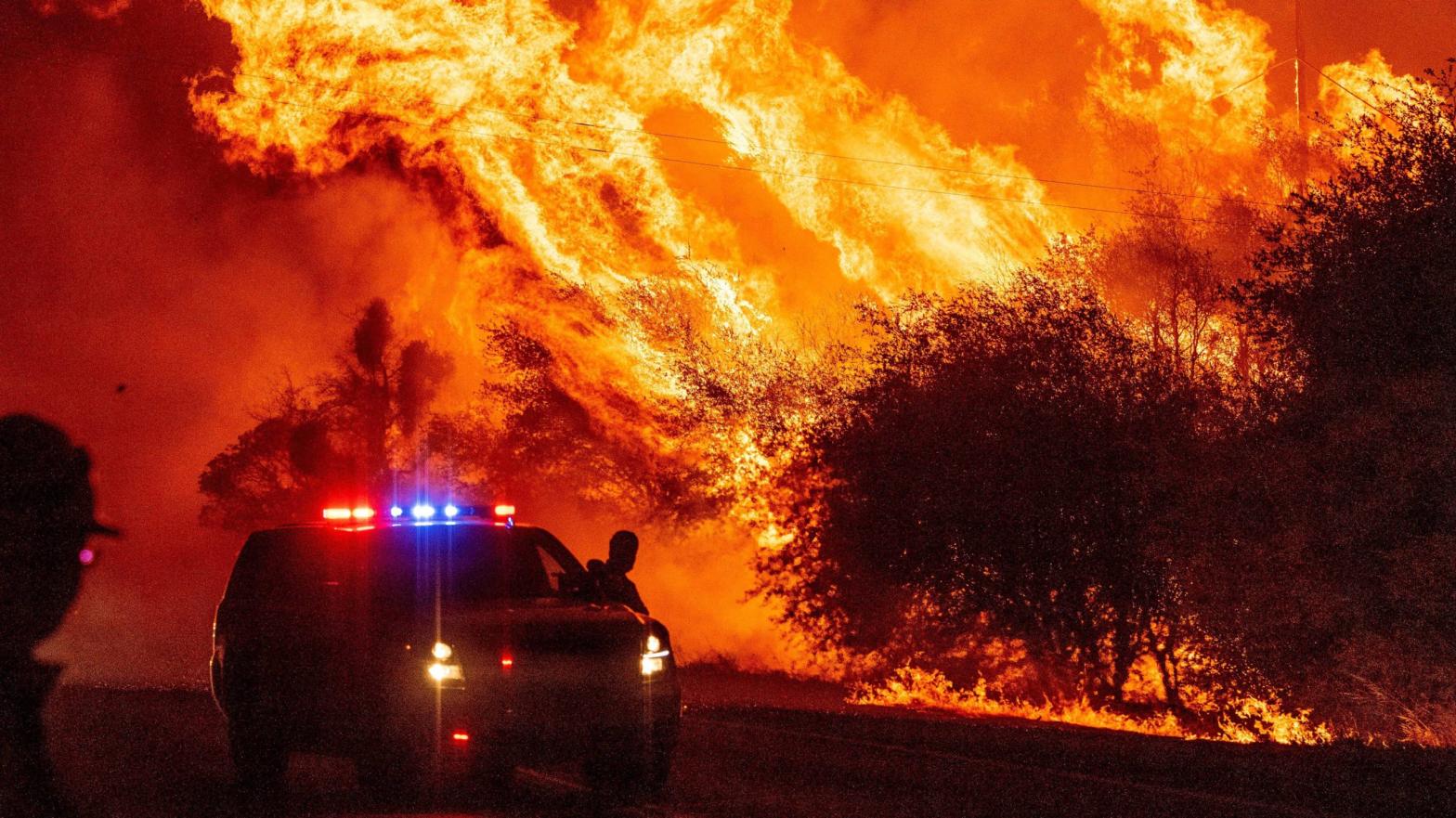 A law enforcement officer watches flames launch into the air as fire continues to spread during the Bear fire in Oroville, California on September 9, 2020. Dangerous dry winds whipped up California's record-breaking wildfires and ignited new blazes, as hundreds were evacuated by helicopter and tens of thousands were plunged into darkness by power outages across the western United States.  (Photo: Josh Edelson/AFP, Getty Images)