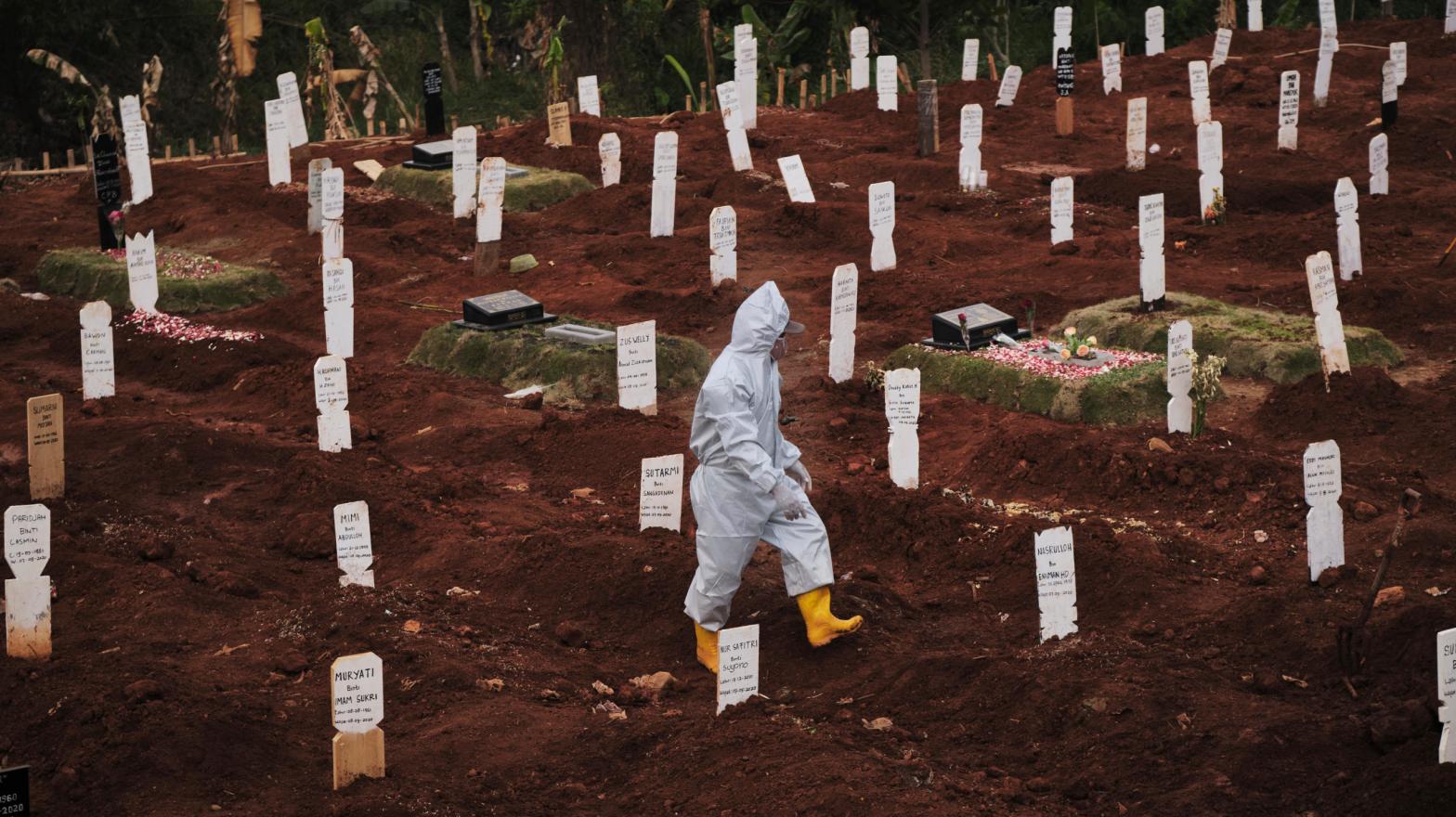 A municipal cemetery worker walks through a special cemetery for suspected covid-19 victims on September 11, 2020 in Jakarta, Indonesia (Photo: Ed Wray, Getty Images)