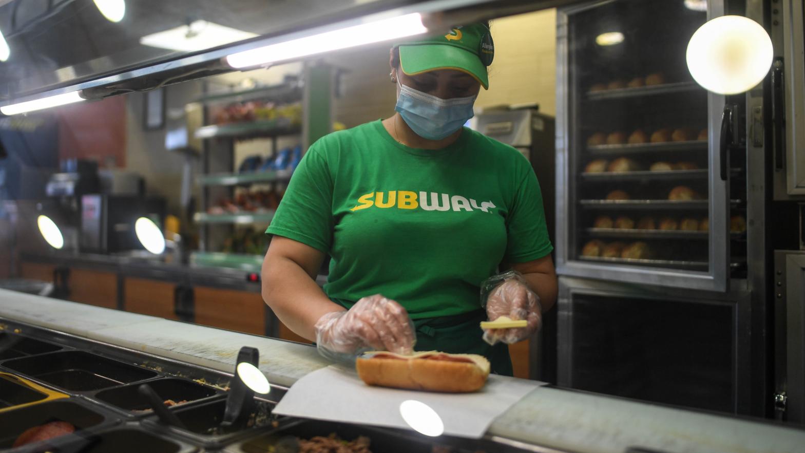 A worker wears a face mask while making a sandwich in a Subway store on June 12, 2020 in London, England. (Photo: Peter Summers, Getty Images)