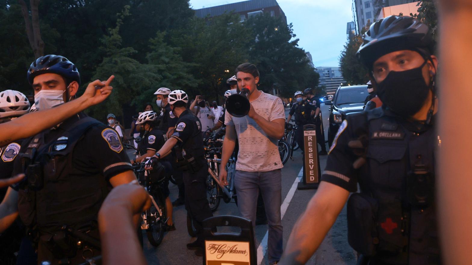 Police surround Jacob Wohl as he taunts protesters in DC on Aug. 27, 2020. (Photo: Michael M. Santiago, Getty Images)