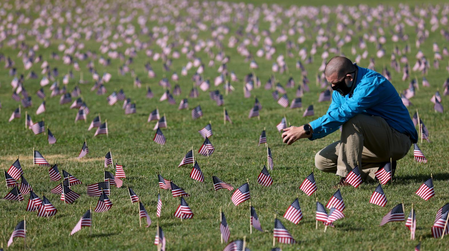 Chris Duncan, whose 75-year-old mother Constance died from the viral illness, photographs a COVID Memorial Project installation of 20,000 American flags meant to mourn the then 200,000 U.S. lives lost in the pandemic on September 22, 2020 in Washington, DC (Photo: Win McNamee, Getty Images)