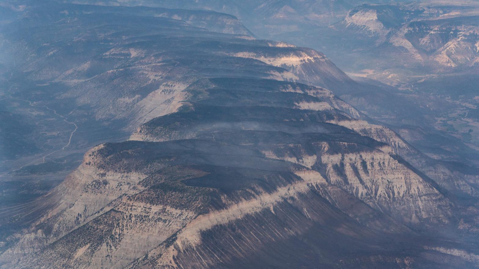 Mountain tops burned by the Pine Gulch Fire sit cleared of fire activity on August 26, 2020 in Grand Junction, Colorado. (Photo: Alex Edelman, Getty Images)