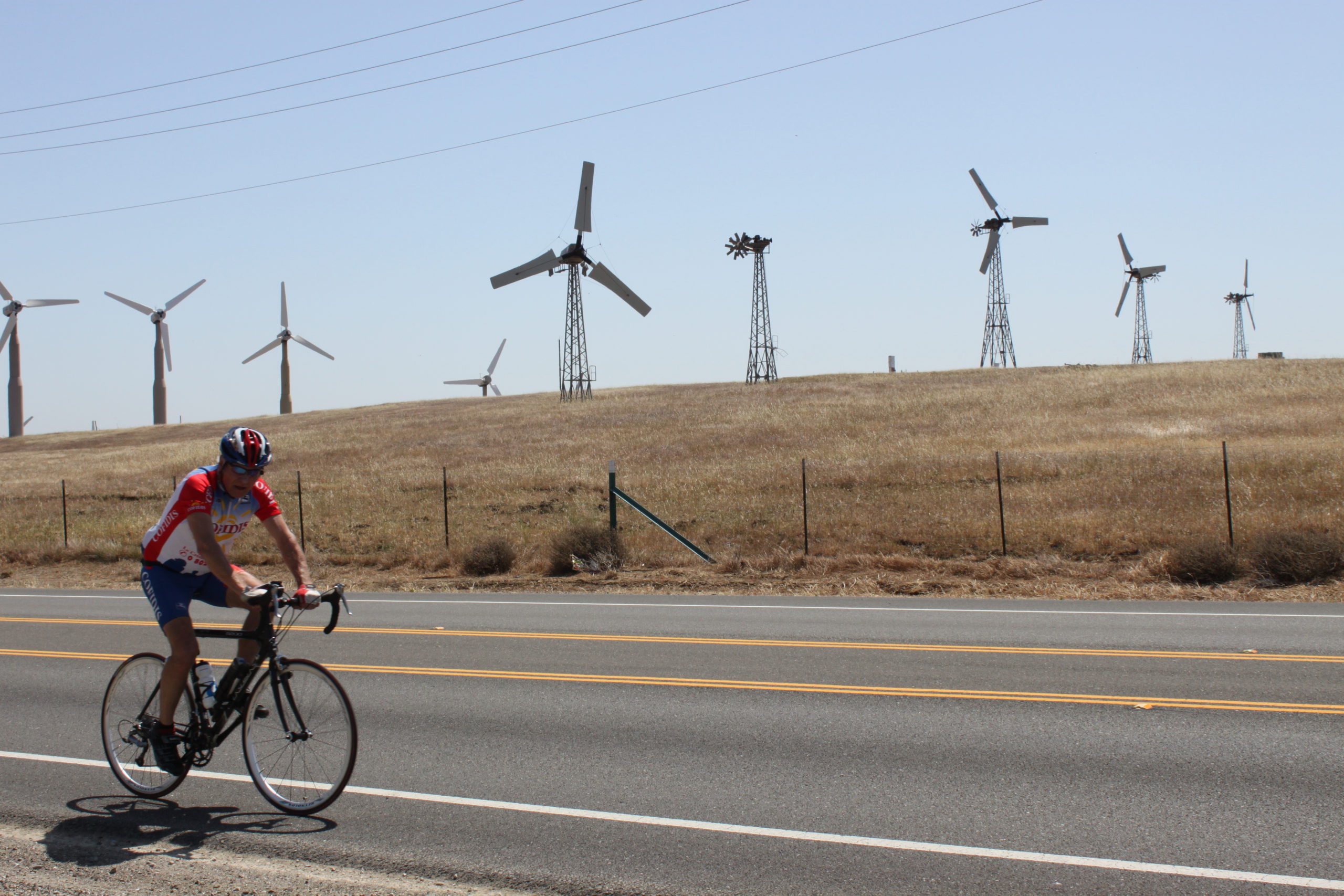 Multiple styles of wind turbines in various states of repair on Altamont Pass. Oh, and a biker. (Photo: Phil Warburg)