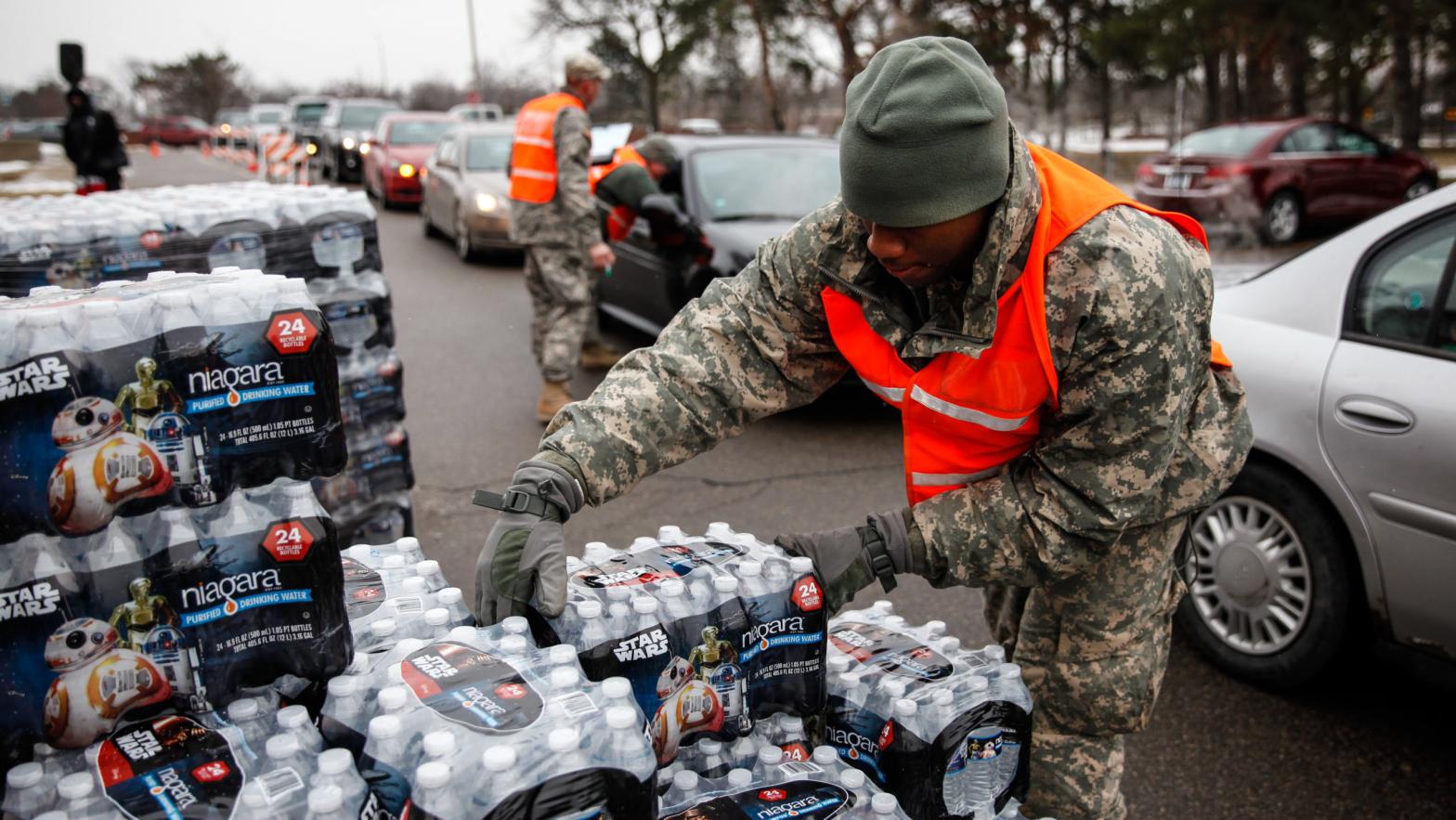 Army National Guard Specialist David Brown loads bottled water into waiting cars at a fire station on Jan. 21, 2016 in Flint, Michigan. (Photo: Sarah Rice, Getty Images)