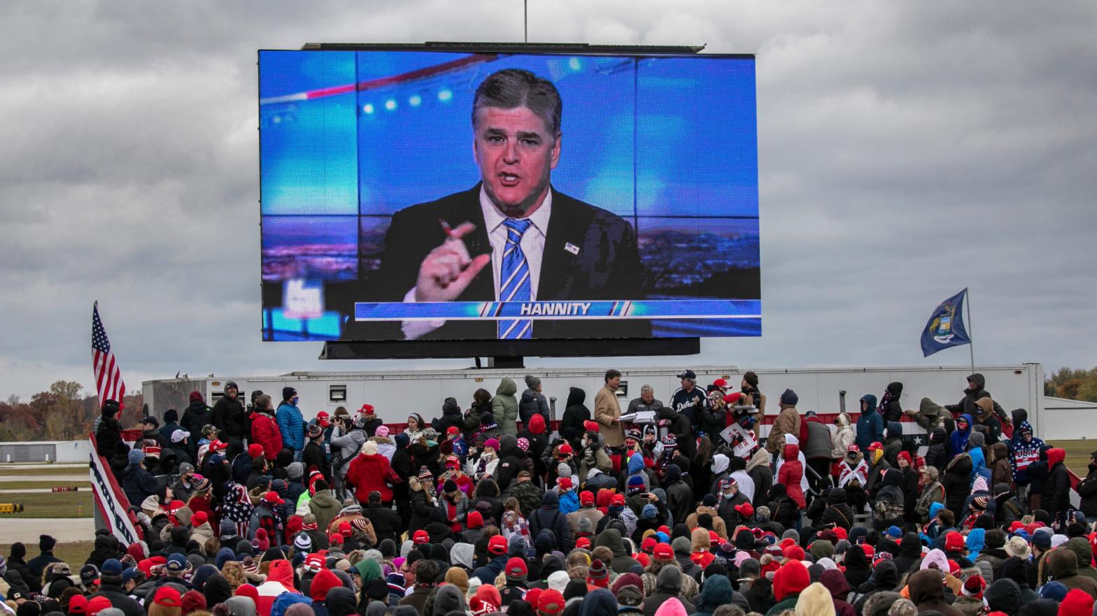 Supporters of U.S. President Donald Trump watch a video featuring Fox host Sean Hannity ahead of Trump's arrival to a campaign rally at Oakland County International Airport on October 30, 2020 in Waterford, Michigan.  (Photo: John Moore, Getty Images)