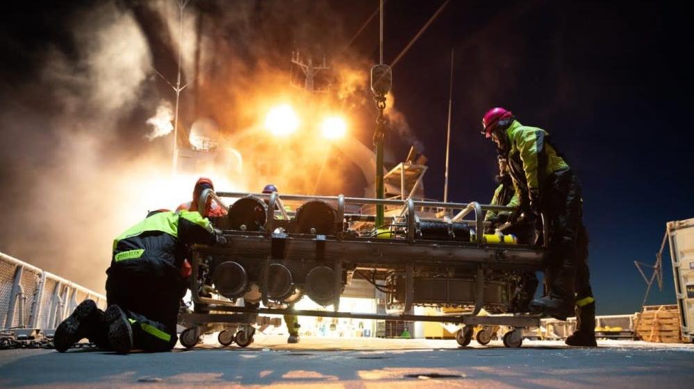 The scientists bring the device they retrieved from the bottom of the ocean onto their ship. (Photo: Norwegian Coast Guard)