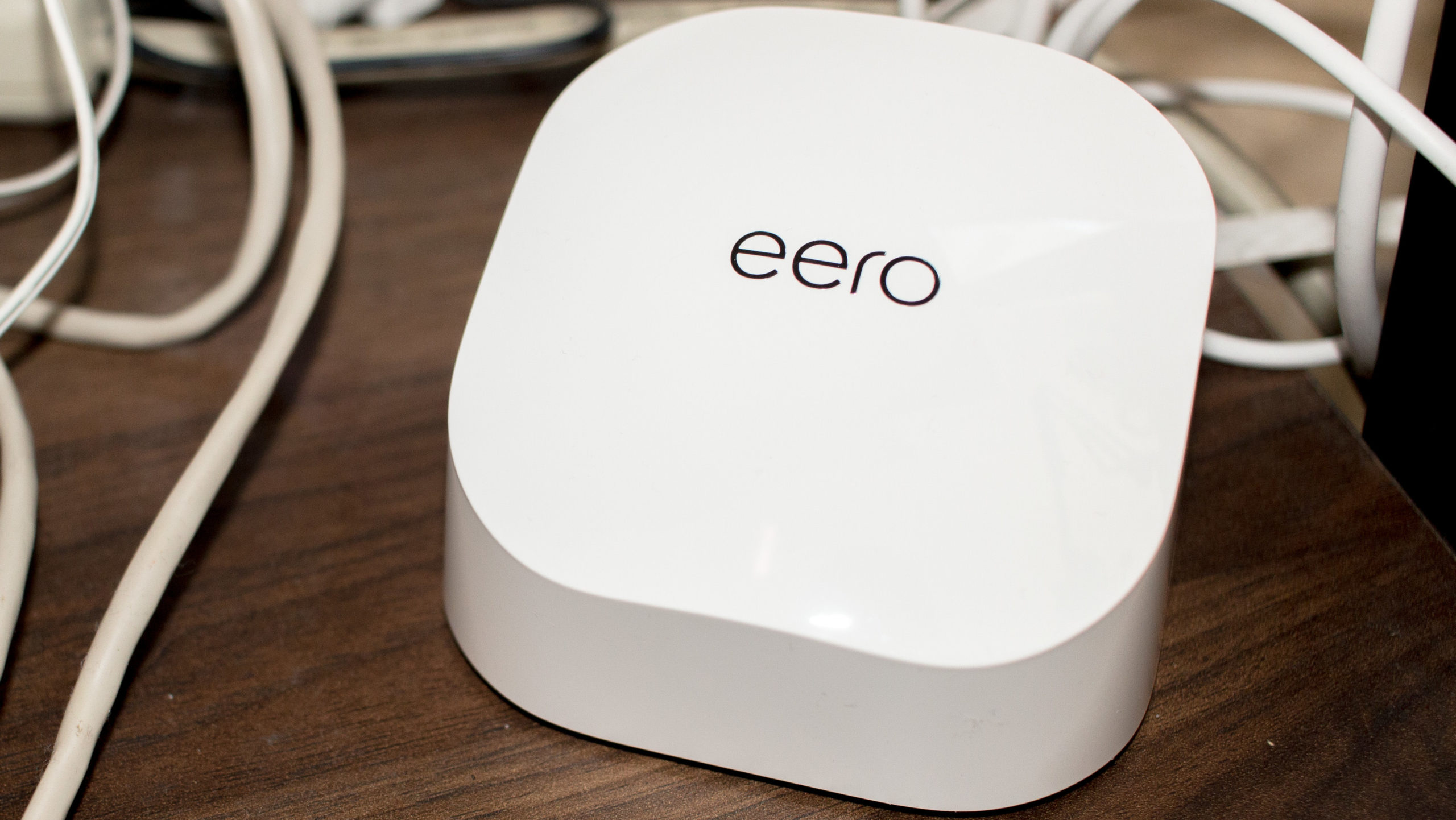 Truly, this is what the Eero 6 looks like: a rectangular puck amongst a mess of cables.  (Photo: Florence Ion/Gizmodo)