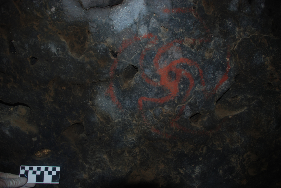 Photo of the Pinwheel painting, with a crevice stuffed with quid shown at lower left above the 10-cm scale.  (Image: David Wayne Robinson)