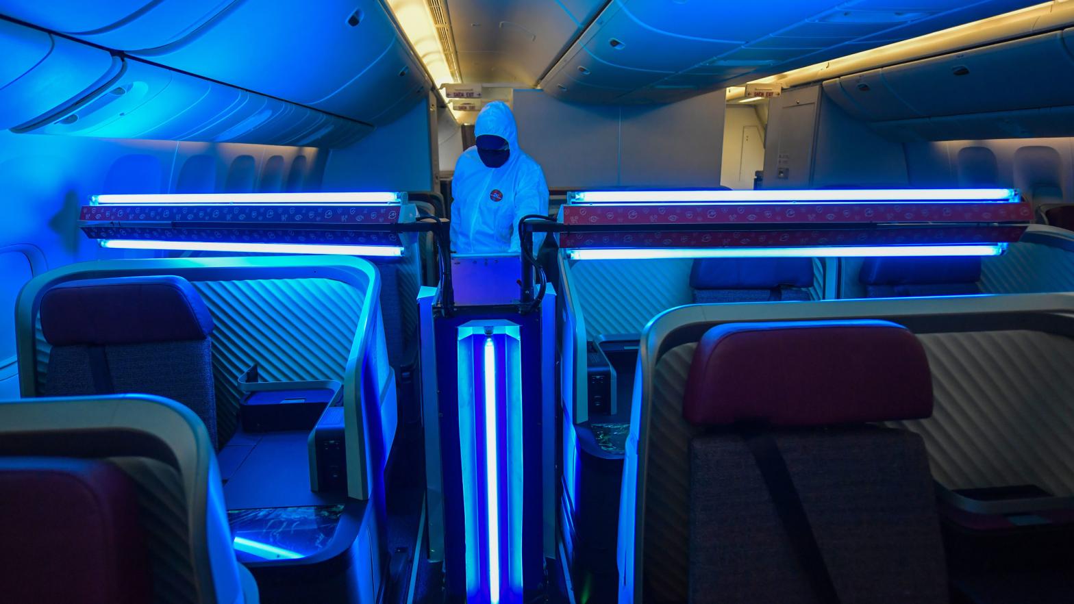An employee of the Chilean-Brazilian airline LATAM monitors the operation of an autonomous robot that uses type C ultraviolet light (UV-C) to clean the interior of the aircraft. (Photo: NELSON ALMEIDA/AFP, Getty Images)
