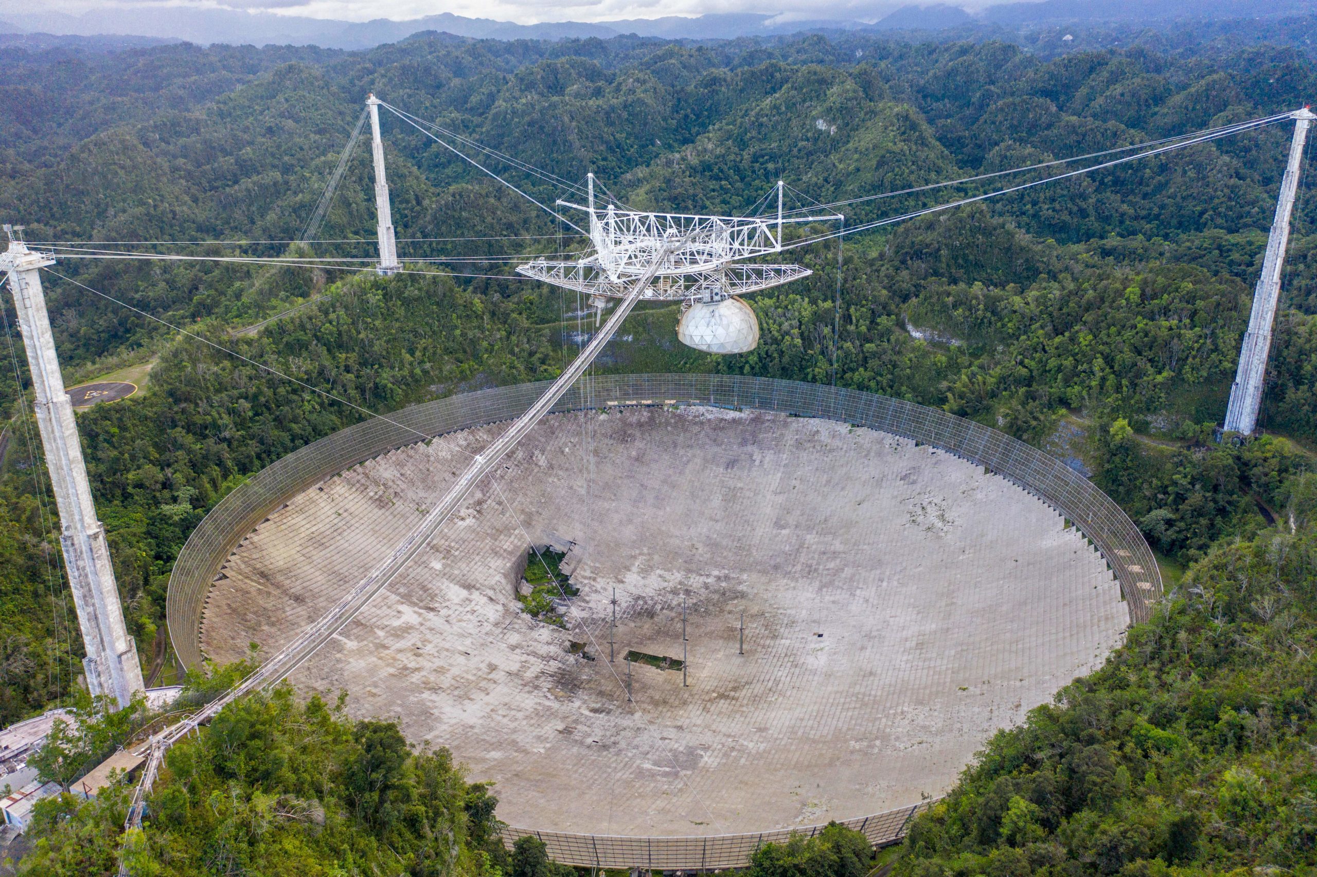 Arecibo as it appeared on November 19, 2020. Previous cable failures caused the visible gashes in the dish.  (Image: Ricardo Arduengo/AFP via Getty Images, Getty Images)