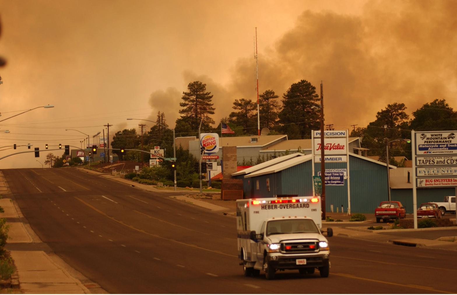 An ambulance from the towns of Heber and Overgaard on June 24, 2002 in Show Low, Arizona as smoke envelops the evacuated town during a wildfire. (Photo: David McNew, Getty Images)