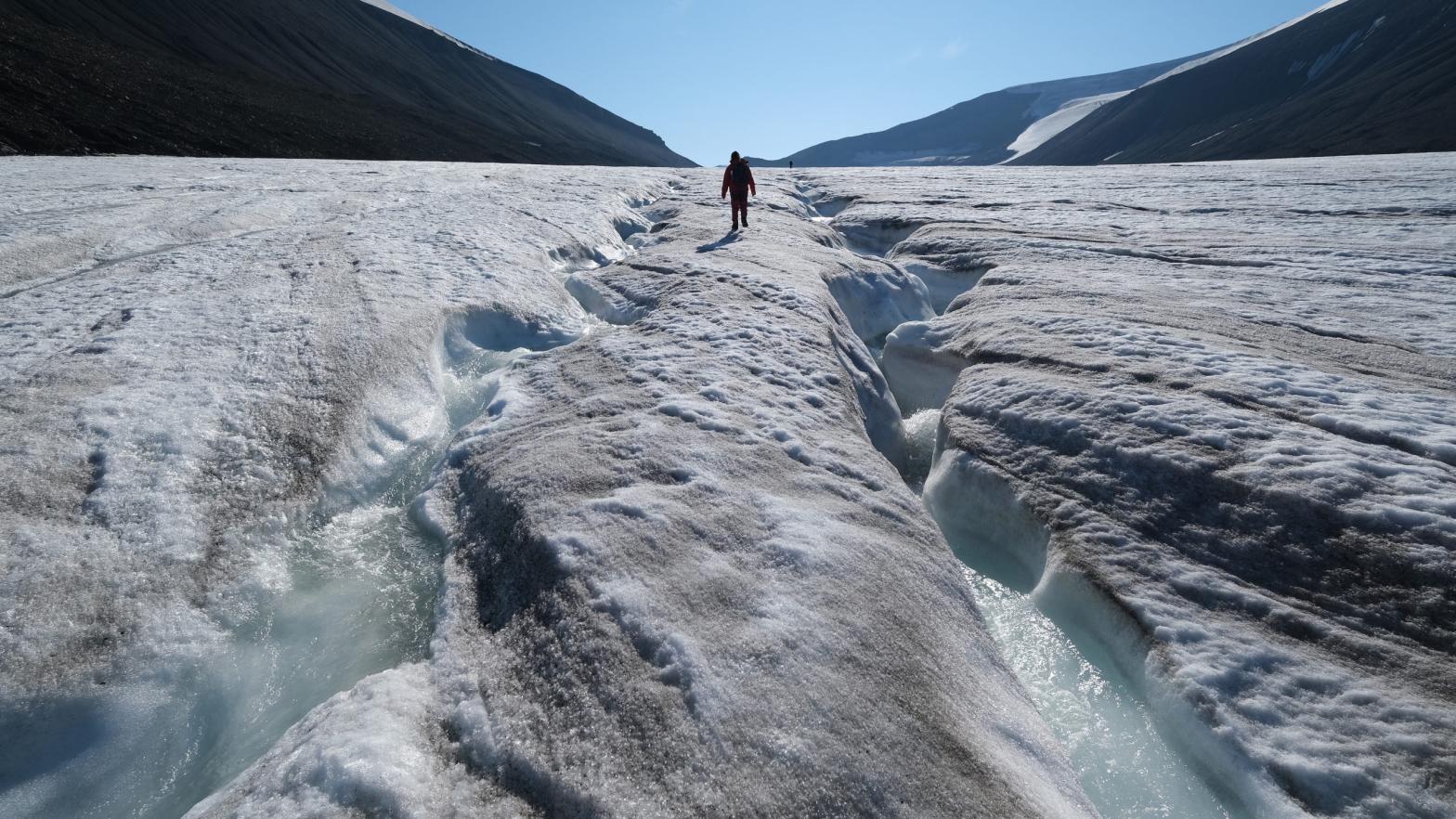 A hiker walks among winding channels carved by water on the surface of the melting Longyearbreen glacier during a summer heat wave on Svalbard archipelago on July 31, 2020. (Photo: Sean Gallup, Getty Images)