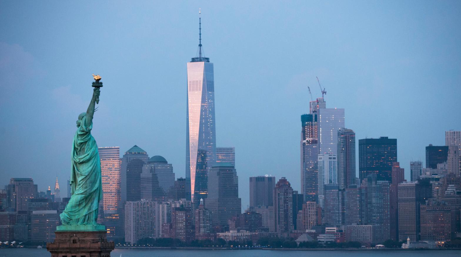 The Statue of Liberty stands in the foreground as Lower Manhattan is viewed at dusk. (Photo: Drew Angerer, Getty Images)