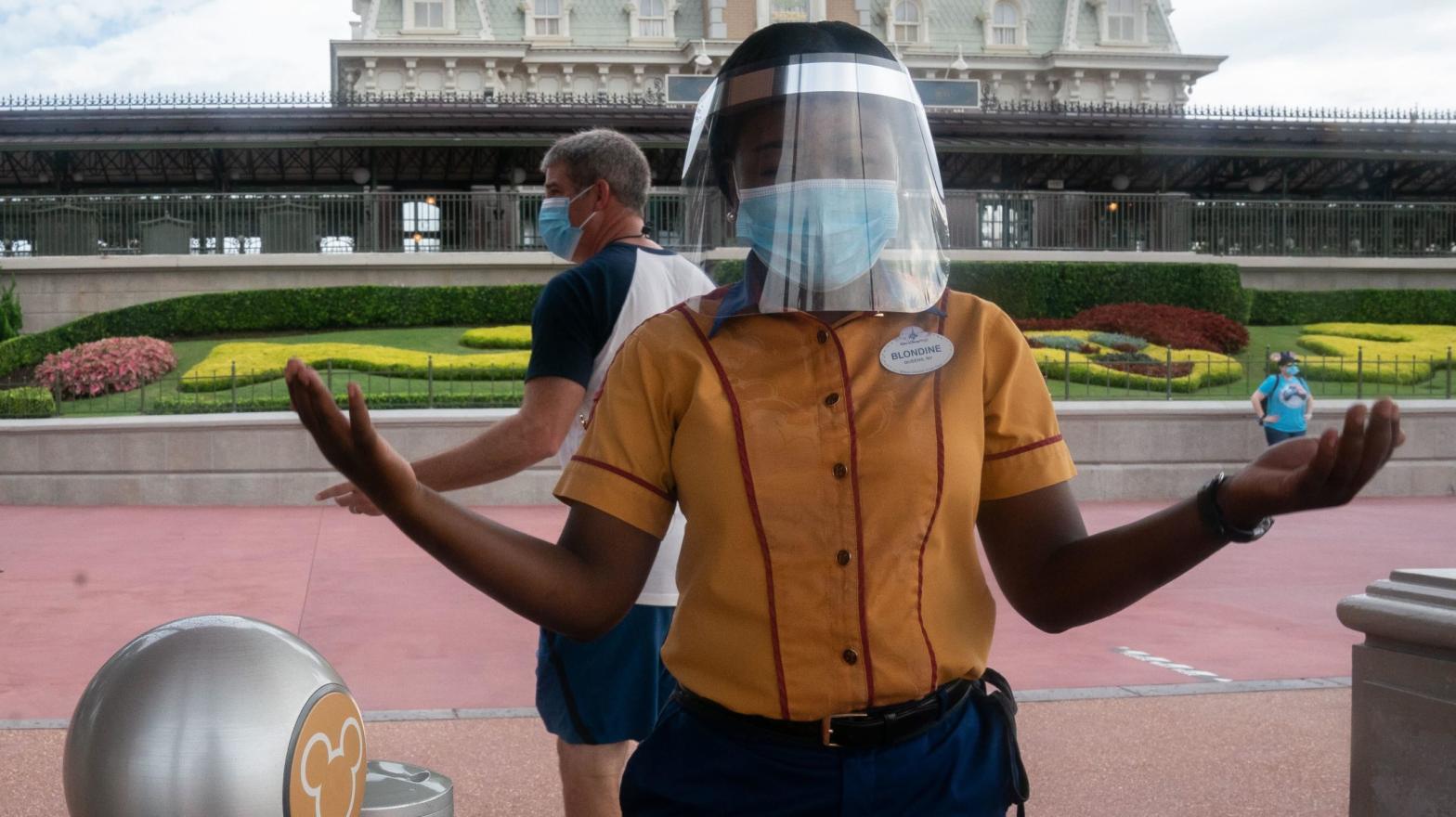 An employee at Walt Disney World Resort's Magic Kingdom wears a facemask and face shield at the entrance to the park during the COVID-19 pandemic in Orlando on July 23, 2020.  (Photo: Bryan Smith, Getty Images)