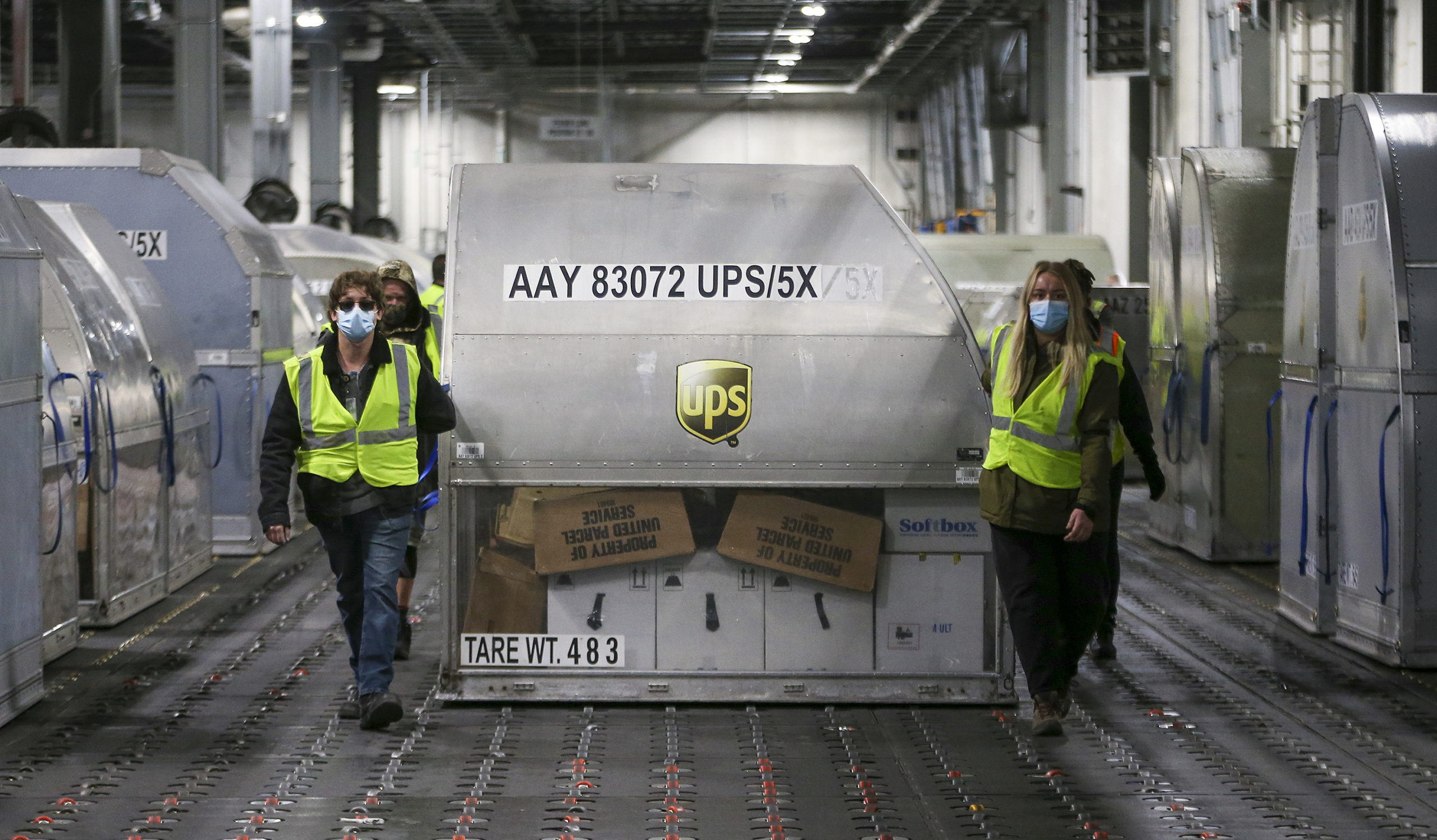 UPS employees move one of two shipping containers containing the first shipments of the Pfizer and BioNTech COVID-19 vaccine inside a sorting facility at UPS Worldport on December 13, 2020 in Louisville, Kentucky. (Photo: Michael Clevenger, Getty Images)