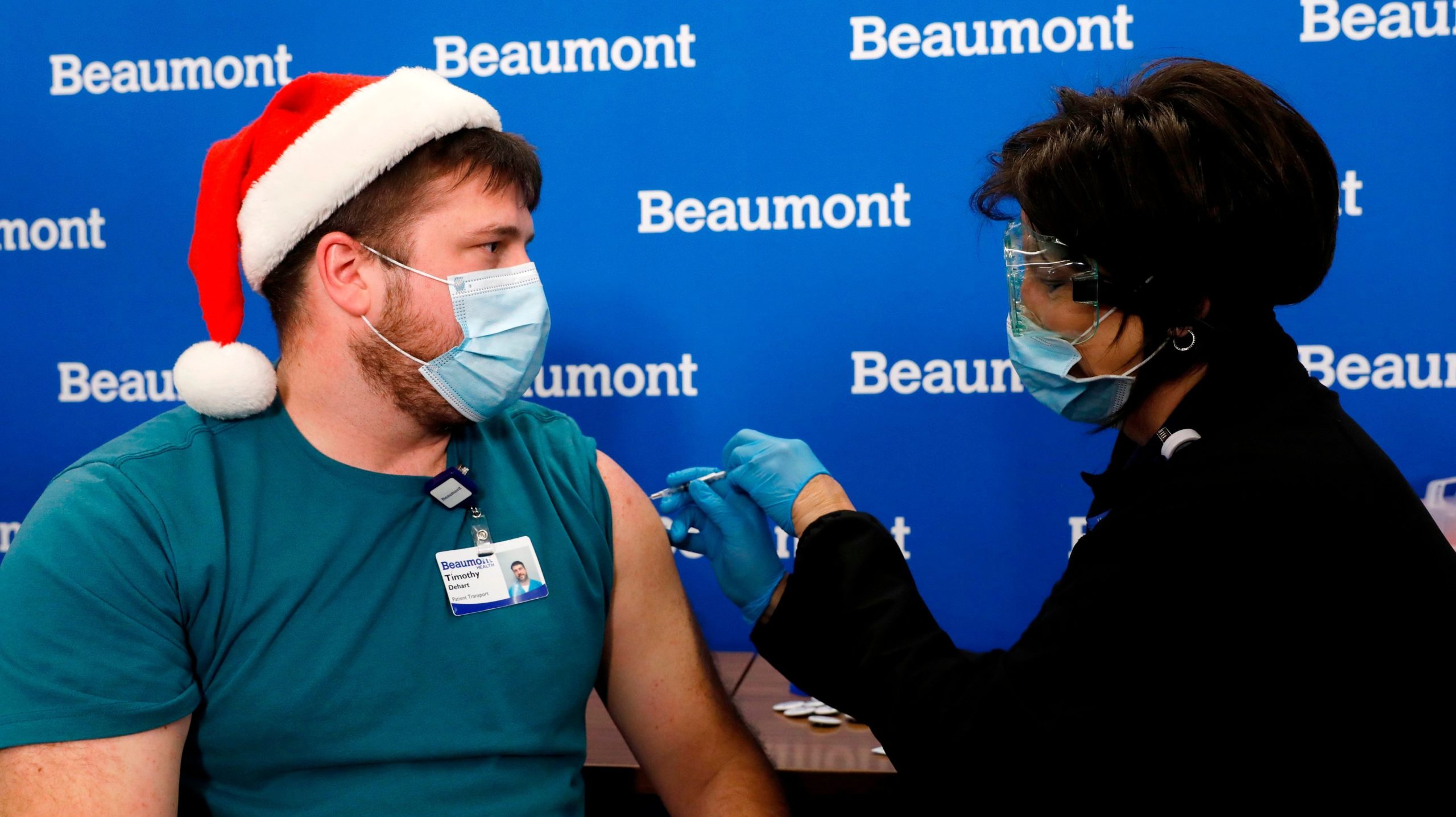 Beaumont Health Care worker Timothy Dehart (L) receives his first dose of the Pfizer/BioNTech covid-19 vaccine by Carolyn Wilson at their service centre in Southfield, Michigan on December 15, 2020.  (Photo: Jeff Kowalsky / AFP, Getty Images)