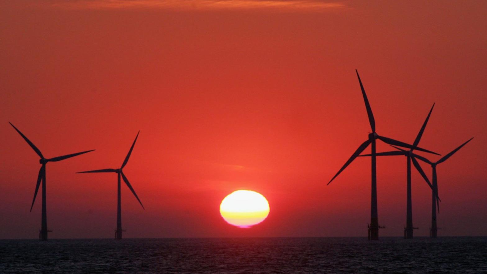 The sun starts to rise behind an offshore wind farm off the Great Yarmouth coastline. (Photo: Matt Cardy, Getty Images)