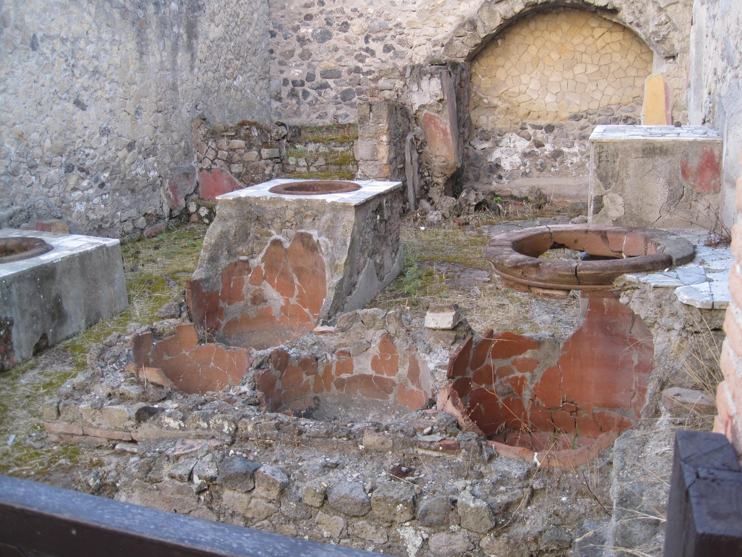 The remains of a thermopolium at Herculaneum (a nearby town that suffered a similar fate as Pompeii) show how the dolia were built into the counter first, and then the counter built around the containers. (Photo: Steven Ellis)