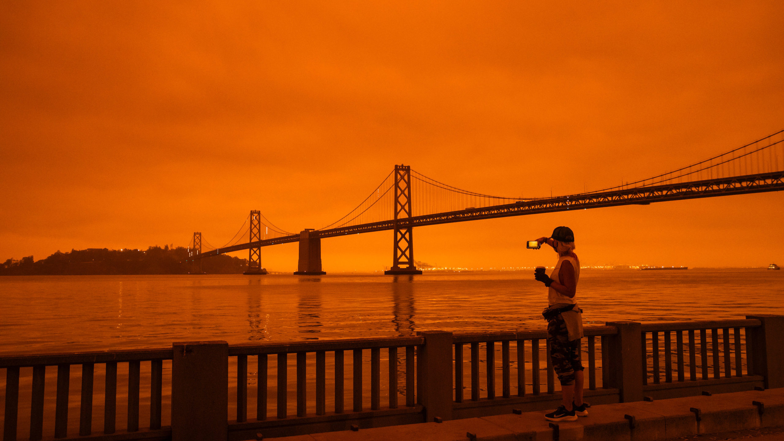 A runner takes a picture of the Bay Bridge in San Francisco under smoke-clogged skies. (Photo: Philip Pacheco, Getty Images)