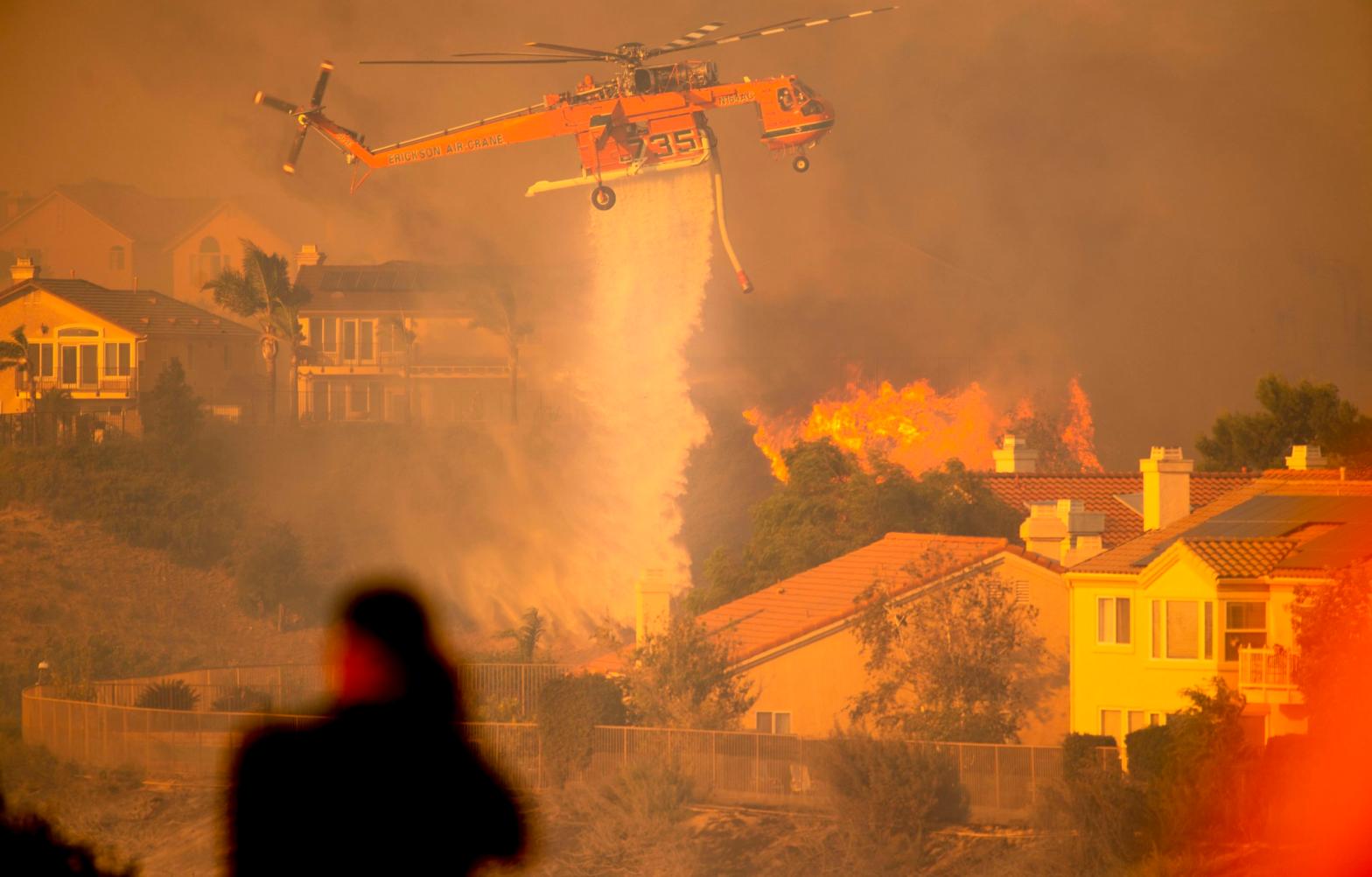 A helicopter drops water to help fight flames as the Saddleridge Fire in the Porter Ranch section of Los Angeles, California on October 11, 2019.  (Photo: Josh Edelson, Getty Images)